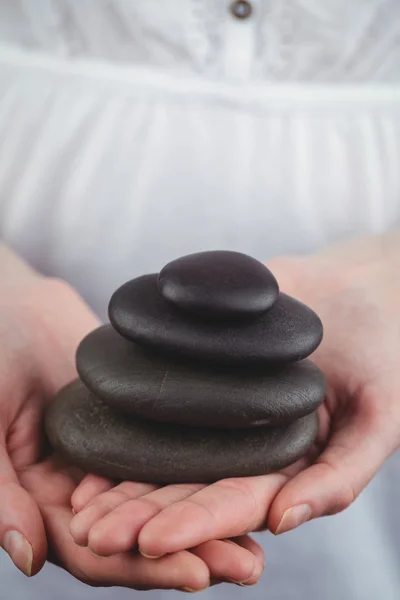 Woman holding black stones — Stock Photo, Image