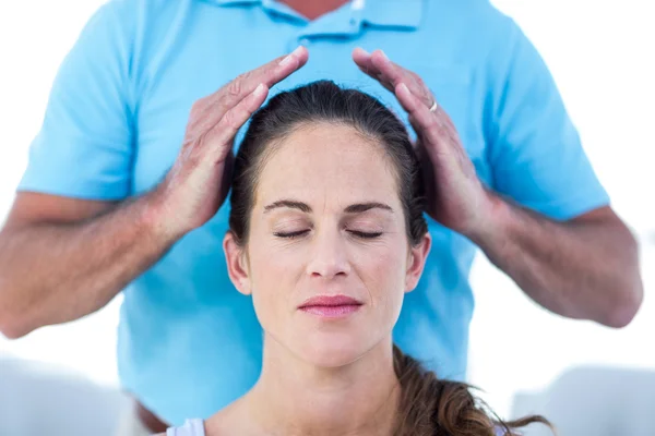 Therapist performing reiki on young woman — Stock Photo, Image