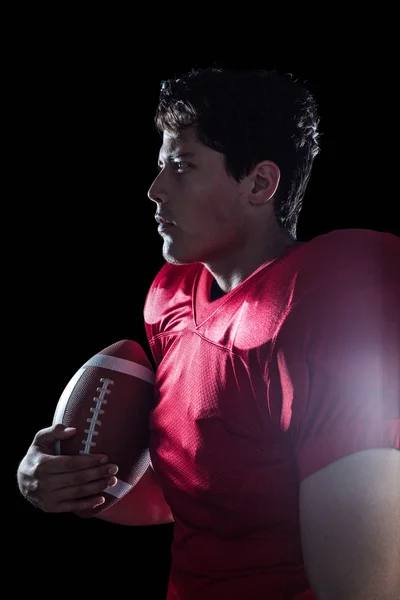 Американский футболист держит мяч — стоковое фото