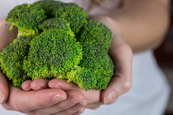 Kadın gösteren taze yeşil brocolli — Stok fotoğraf