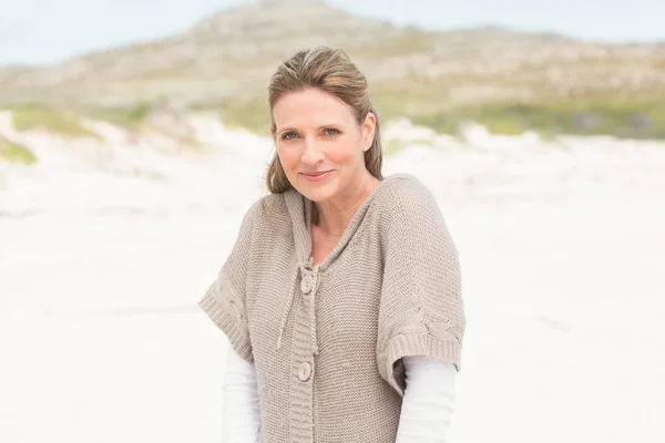 Usmívající se žena stojí na písku — Stock fotografie