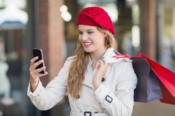 A smiling woman using her phone — Stock Photo, Image