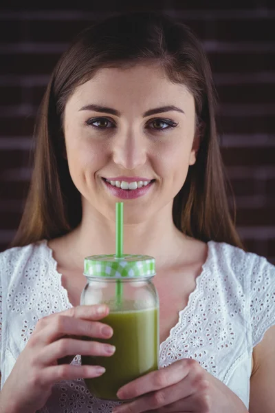 Όμορφη γυναίκα πίνοντας σε πράσινο χυμό — Φωτογραφία Αρχείου