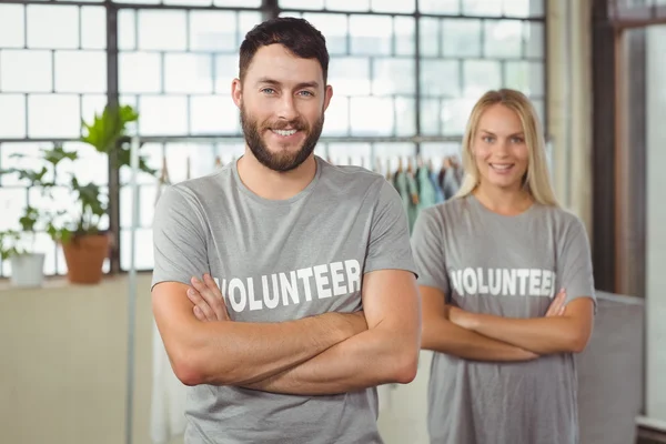 Glada volontär med armarna korsade — Stockfoto