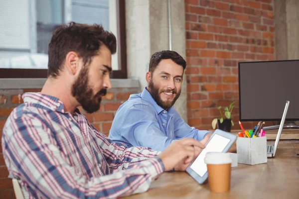 Smiling businessman sitting by colleague — Stock Photo, Image