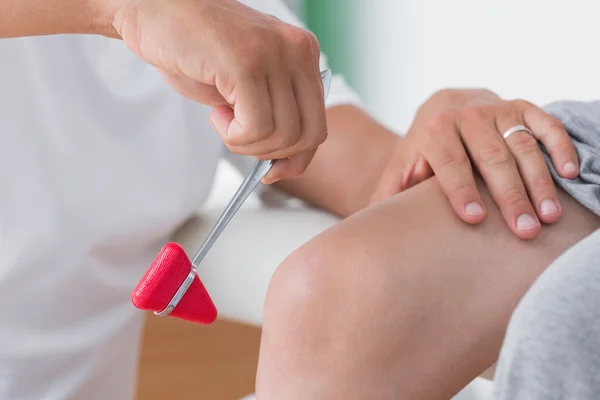 Doctor checking reflexes of knee of patient — Stock Image Doctor checking reflexes of knee of patient Stock Picture