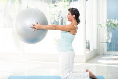 Pregnant woman holding exercise ball clipart