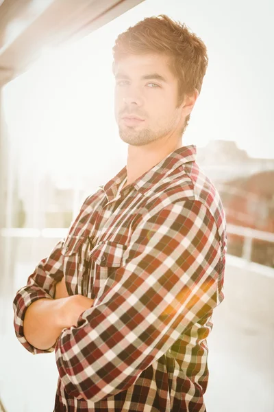 Confident hipster with arms crossed standing by window — Stock Photo, Image