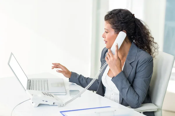 Businesswoman talking on phone while working — Stock Photo, Image