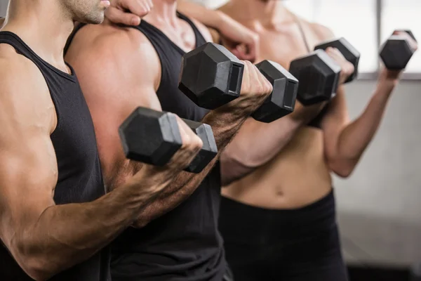 People at gym lifting dumbbell — Stock Photo, Image