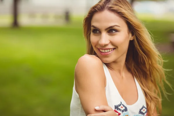 Vrolijke vrouw op zoek weg terwijl je op gras — Stockfoto