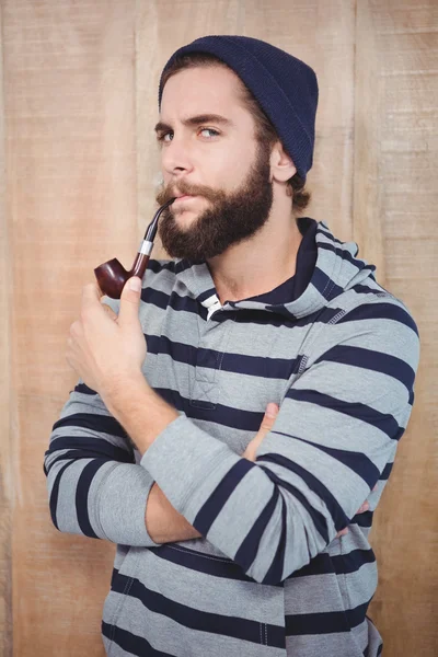 Portrait of serious hipster smoking pipe — Stock Photo, Image
