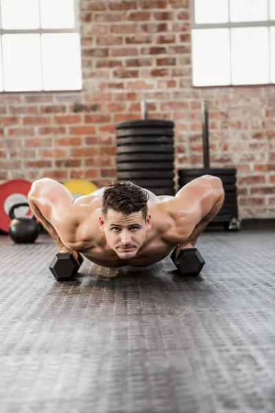 Portret van shirtless man doen halter push ups — Stockfoto