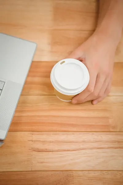 Man håller disponibel cup på tabell i office — Stockfoto