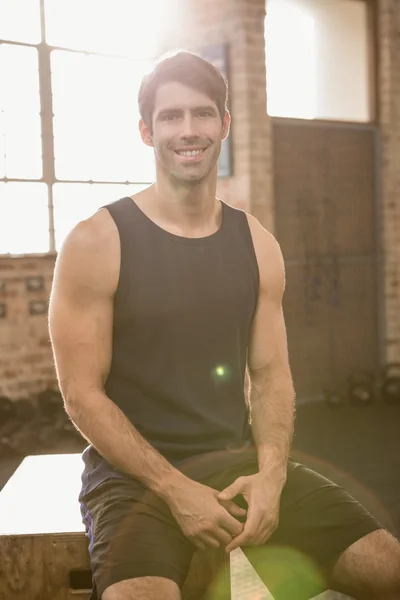 Portrait d'un homme souriant assis sur une boîte de plyo — Photo