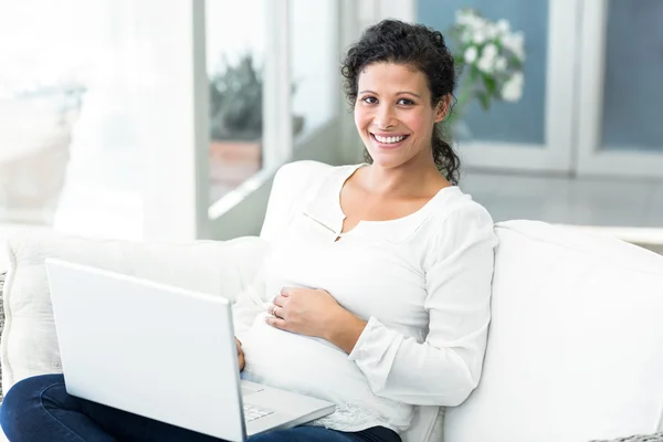 Retrato de mujer feliz usando el ordenador portátil en el sofá — Foto de Stock