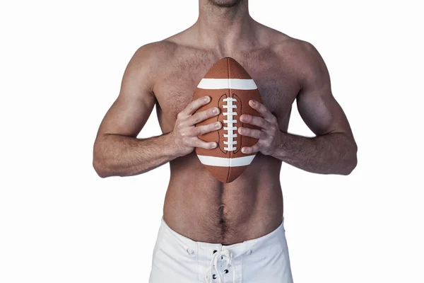Midsection of shirtless rugby player holding ball — Stock Photo, Image