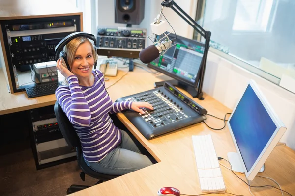 Hospedeira de rádio feminina feliz na mesa de mixer de som em estúdio — Fotografia de Stock