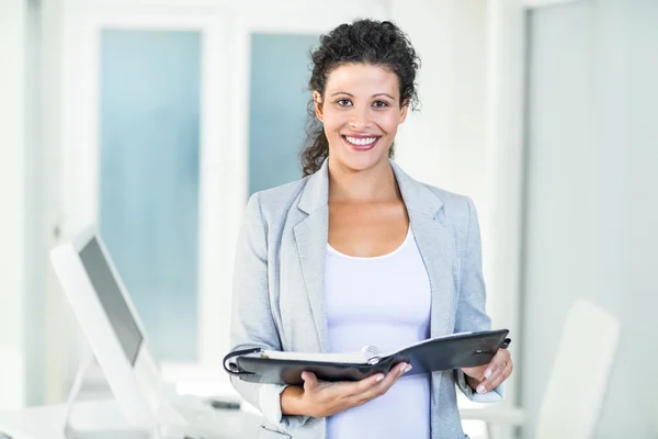 Smiling beautiful businesswoman holding document — Stock Photo, Image
