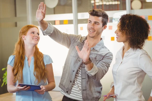 Zakenman gebaren terwijl vrouwelijke collega's kijken naar hem — Stockfoto