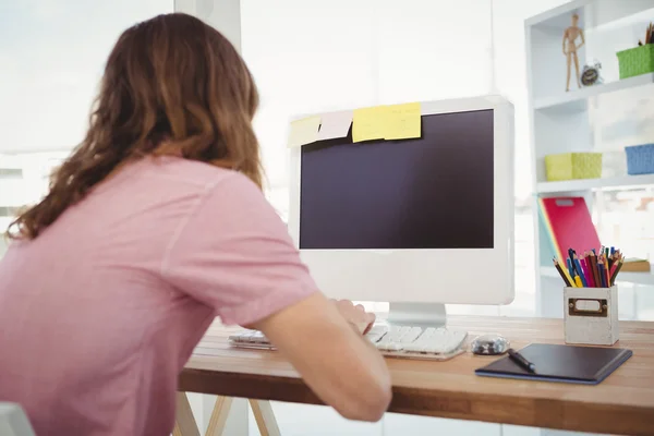 Rear view of hipster working on computer — Stock Photo, Image