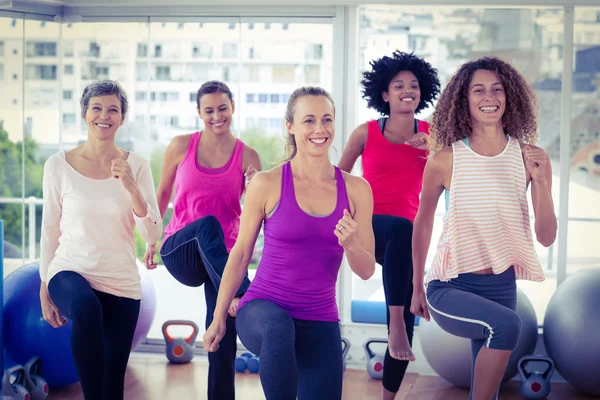 Mujeres sonrientes haciendo ejercicio con las manos apretadas — Foto de Stock