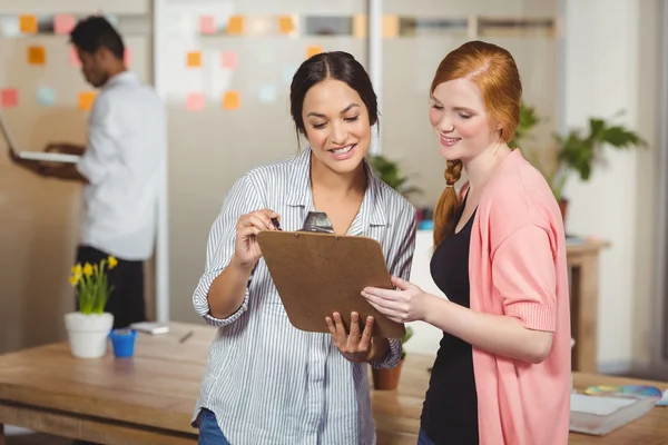 Felice donne d'affari guardando appunti in ufficio — Foto Stock