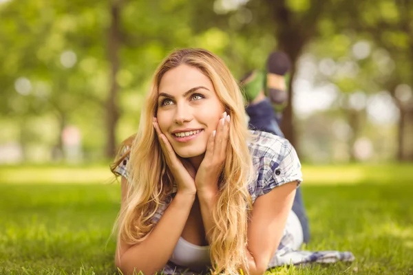 Smiling thoughtful woman lying on front — Stock Photo, Image