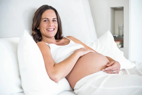 Porträtt av gravid kvinna på sängen — Stockfoto