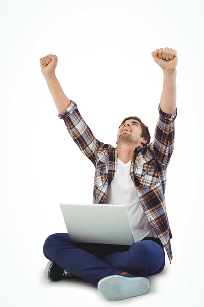 Hipster with laptop on lap cheering with arms raised — Stock Photo, Image