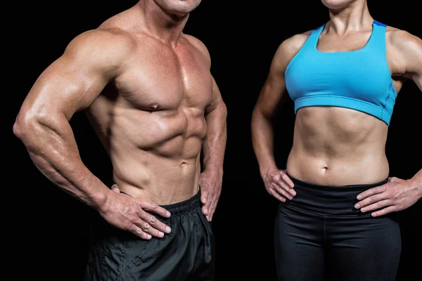 Hombre y mujer musculosos con las manos en la cadera —  Fotos de Stock