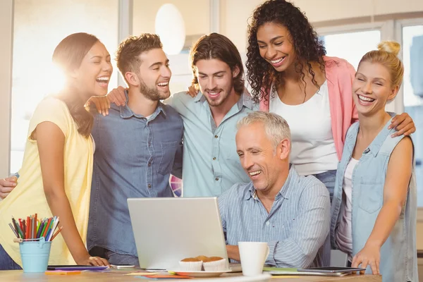 Business people looking at laptop in meeting room — Stock Photo, Image