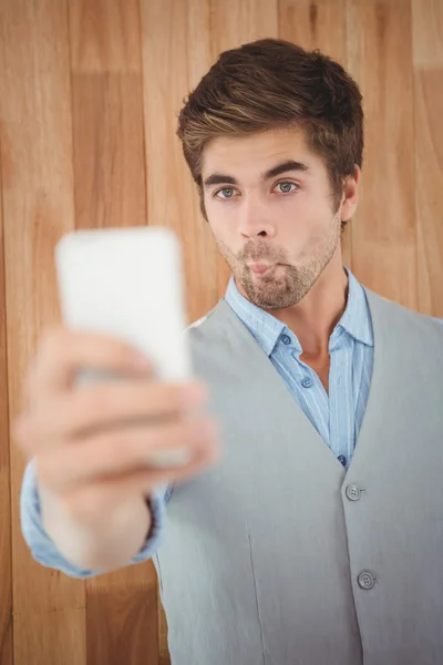 Empresário fazendo cara enquanto toma selfie — Fotografia de Stock