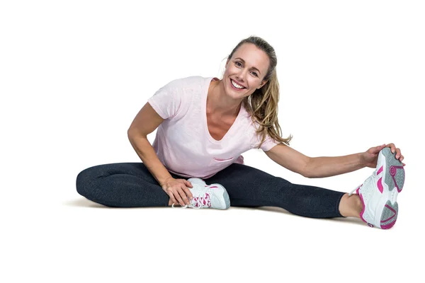 Cheerful woman touching toes while exercising — Stock Photo, Image