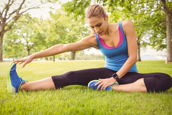 Sportliche Frau streckt Bein — Stockfoto