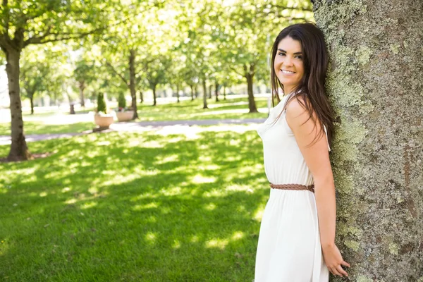 Porträt einer glücklichen Frau, die sich an einen Baum lehnt — Stockfoto