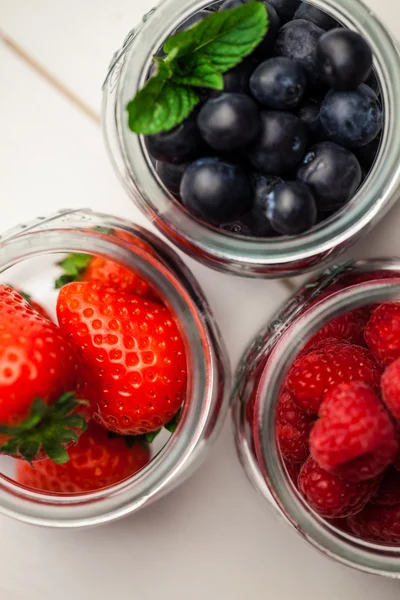 Glass jars of fresh berries — Stock Photo, Image