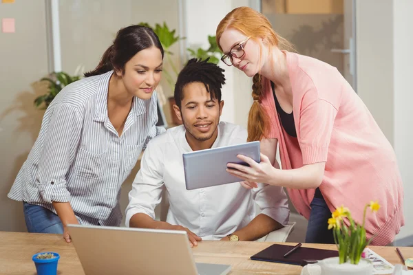 Geschäftsfrau zeigt Kollegen auf digitalem Tablet etwas — Stockfoto