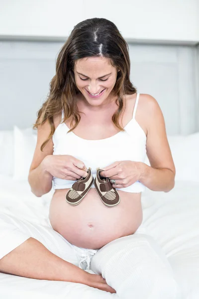 Gelukkige vrouw met laarzen op buik — Stockfoto