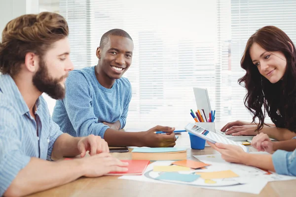 Portrait of smiling man working with coworkers — Stock Photo, Image