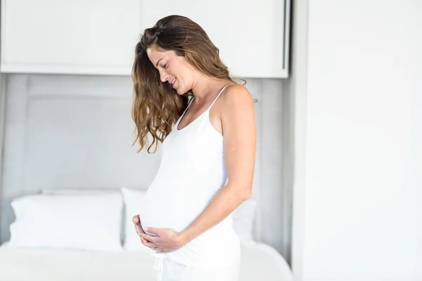 Heureuse femme enceinte debout dans la chambre — Photo