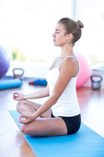 Sidovy av kvinna gör meditation på yogamatta — Stockfoto