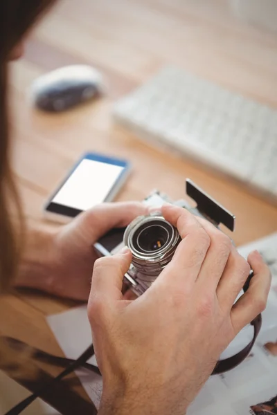 Oříznutí obrazu člověka seřízení objektivu fotoaparátu na stůl — Stock fotografie