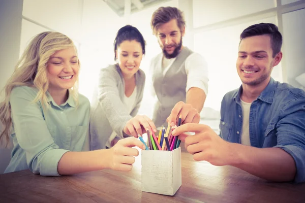 Empresários sorridentes a tomar lápis — Fotografia de Stock