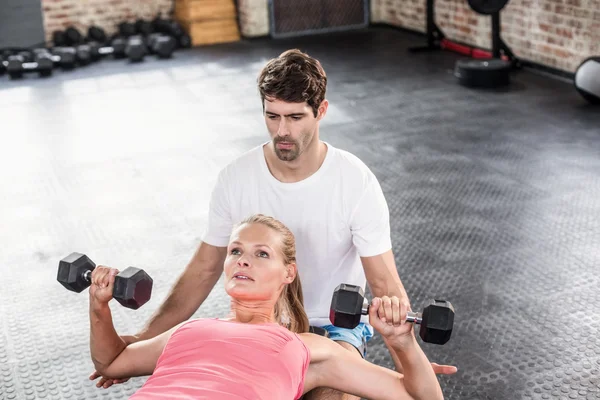 Fitte Frau beim Hantelheben mit Trainer — Stockfoto