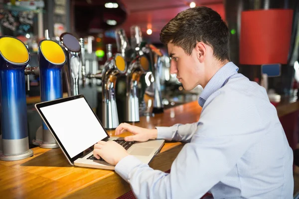 Człowiek za pomocą laptopa na kontuar barowy — Zdjęcie stockowe