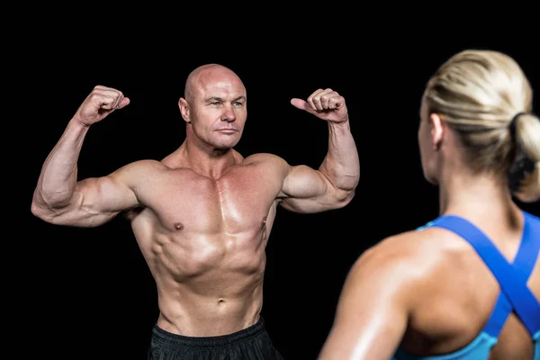 Bodybuilder flexar muskler framför tränare — Stockfoto
