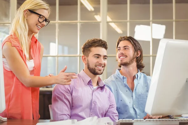 Mannelijke collega's kijken naar zakenvrouw — Stockfoto