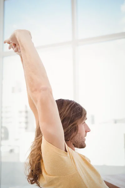 Hipster stretching arms in office — Stock Photo, Image