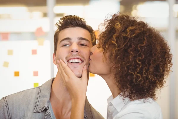 Vrouw met krullend haar kussen zakenman — Stockfoto